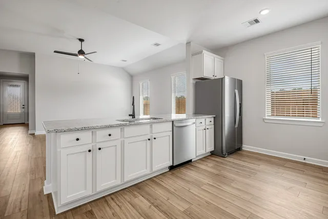 a kitchen with refrigerator cabinets and wooden floor