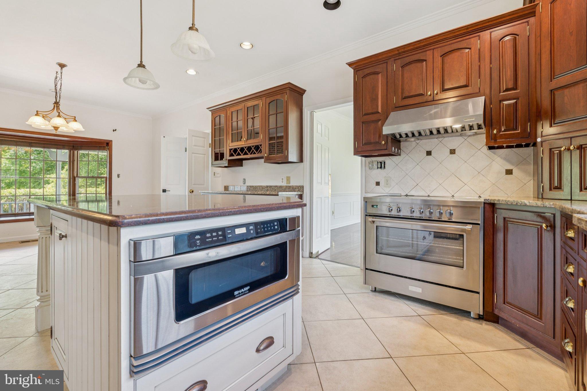 12212 Mt Albert Road Ellicott City, MD 21042 - Photo 18 of 58 a kitchen with stainless steel appliances granite countertop a stove microwave and cabinets