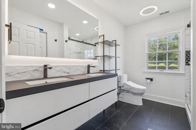 a bathroom with a toilet sink and mirror