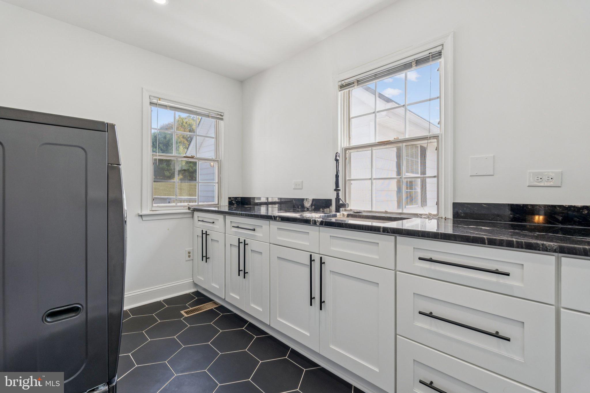 12212 Mt Albert Road Ellicott City, MD 21042 - Photo 30 of 58 a kitchen with granite countertop white cabinets and sink