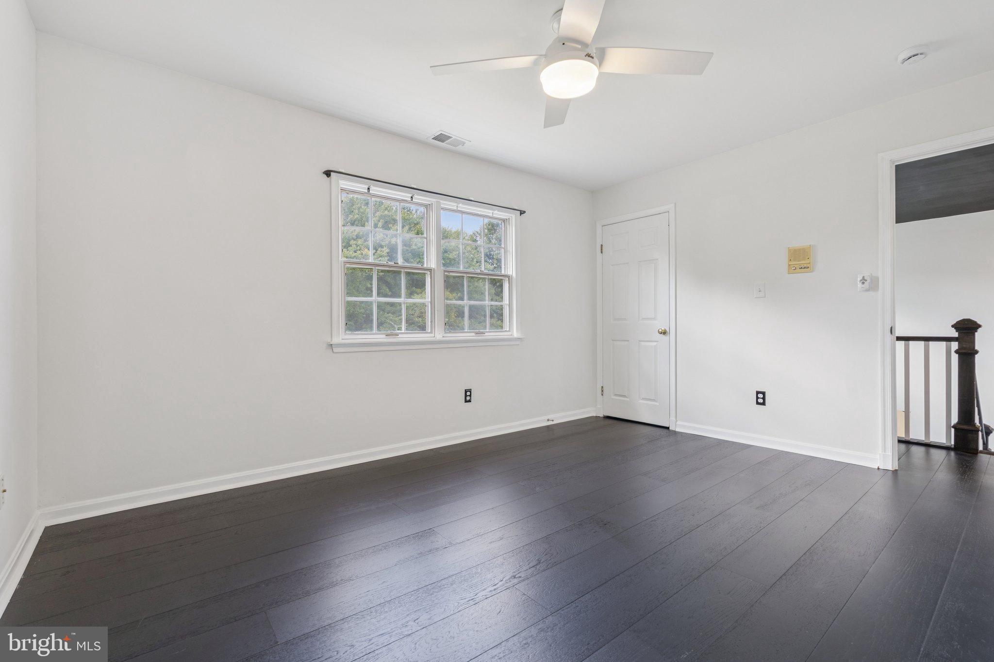 12212 Mt Albert Road Ellicott City, MD 21042 - Photo 35 of 58 an empty room with wooden floor fan and windows
