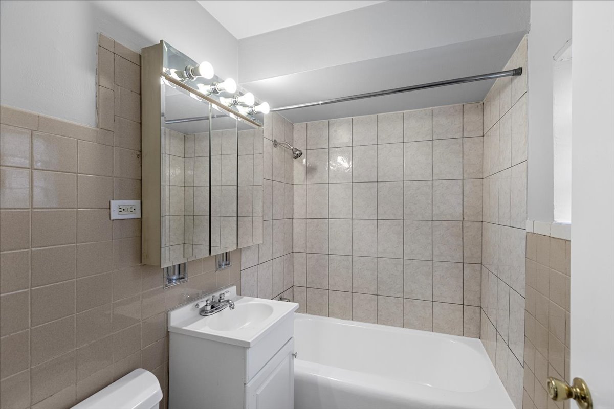 6256 West 64th Place, Unit 104 Chicago, IL 60638 - Photo 13 of 19 a bathroom with a sink a toilet a shower and a mirror