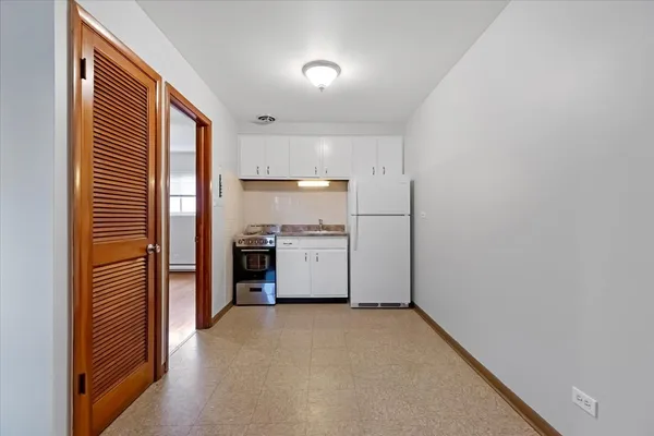 a view of a kitchen with a sink and refrigerator