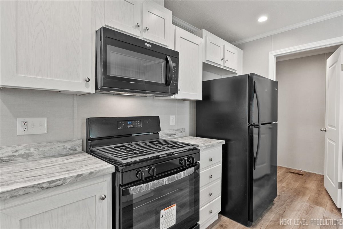 310 Apollo Court Round Lake, IL 60073 - Photo 9 of 38 a kitchen with stainless steel appliances white cabinets and a stove top oven