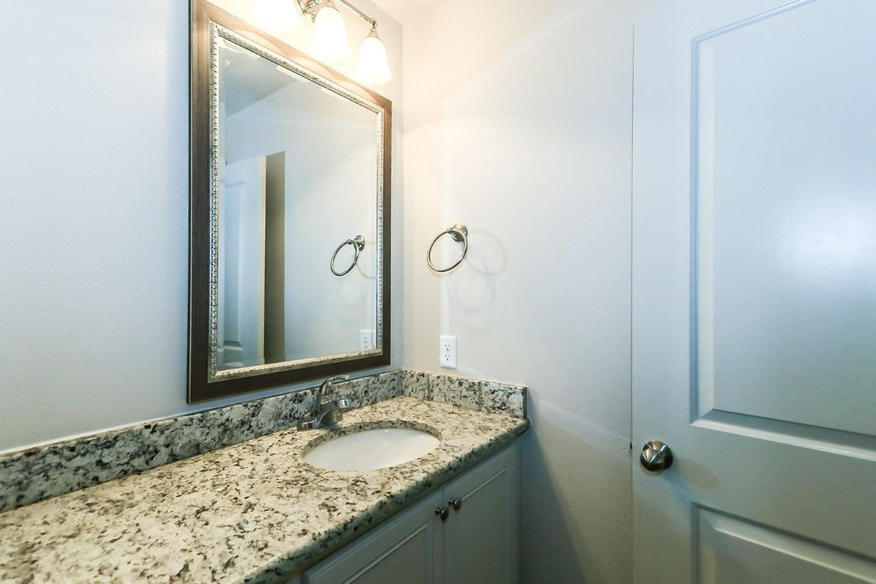 3811 133rd Street Lubbock, TX 79423 - Photo 8 of 12 a bathroom with a granite countertop sink and mirror