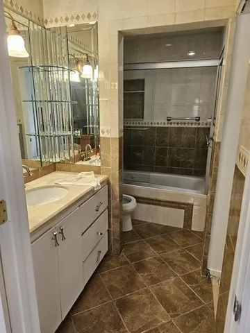 a bathroom with a double vanity sink toilet and shower
