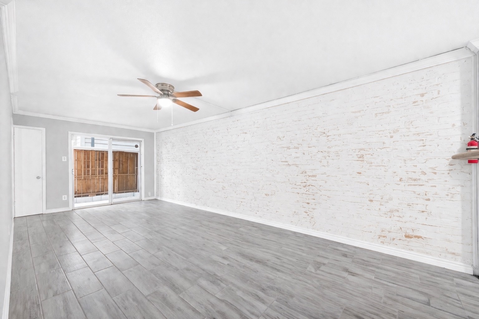1418 Vermont Street, Unit 3 Houston, TX 77006 - Photo 3 of 14 an empty room with wooden floor fan and windows