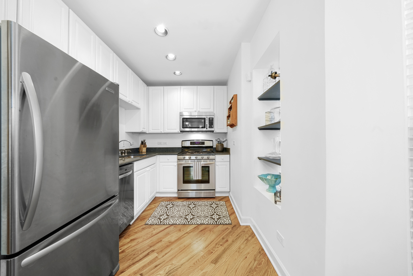 712 West Roscoe Street, Unit 3D Chicago, IL 60657 - Photo 3 of 23 a kitchen with stainless steel appliances a refrigerator and a stove