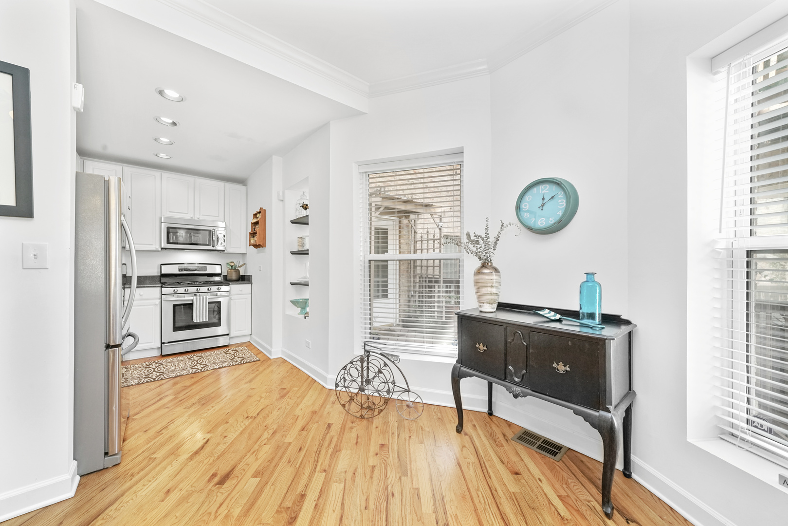 712 West Roscoe Street, Unit 3D Chicago, IL 60657 - Photo 4 of 23 a kitchen with granite countertop a stove a refrigerator and wooden floor