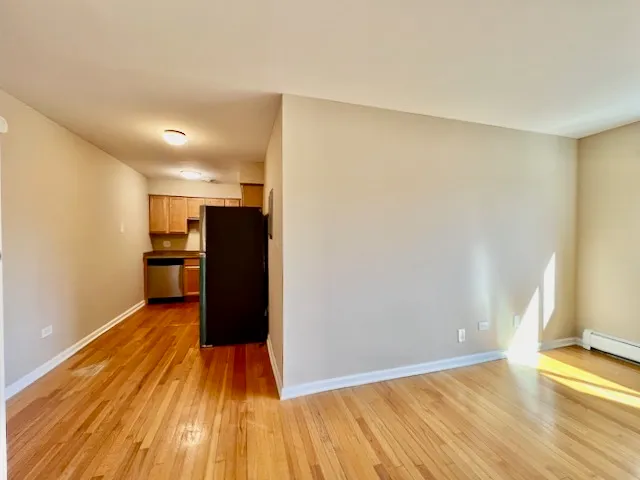 a view of a kitchen with wooden floor and a refrigerator
