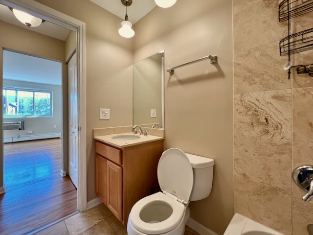 1415 West Lunt Avenue, Unit 304 Chicago, IL 60626 - Photo 8 of 14 a bathroom with a granite countertop toilet sink and mirror