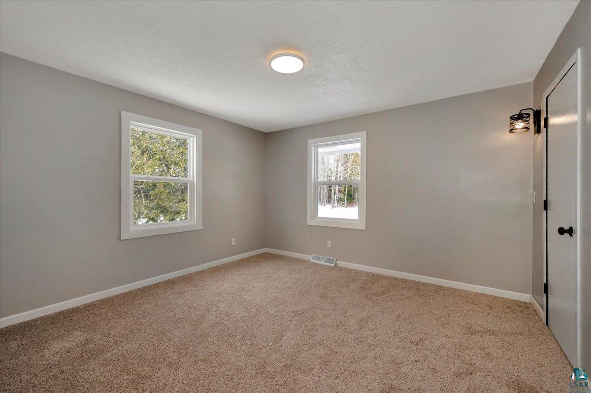 1146 Two Harbors Road Two Harbors, MN 55616 - Photo 11 of 39 Empty room with light colored carpet and a textured ceiling