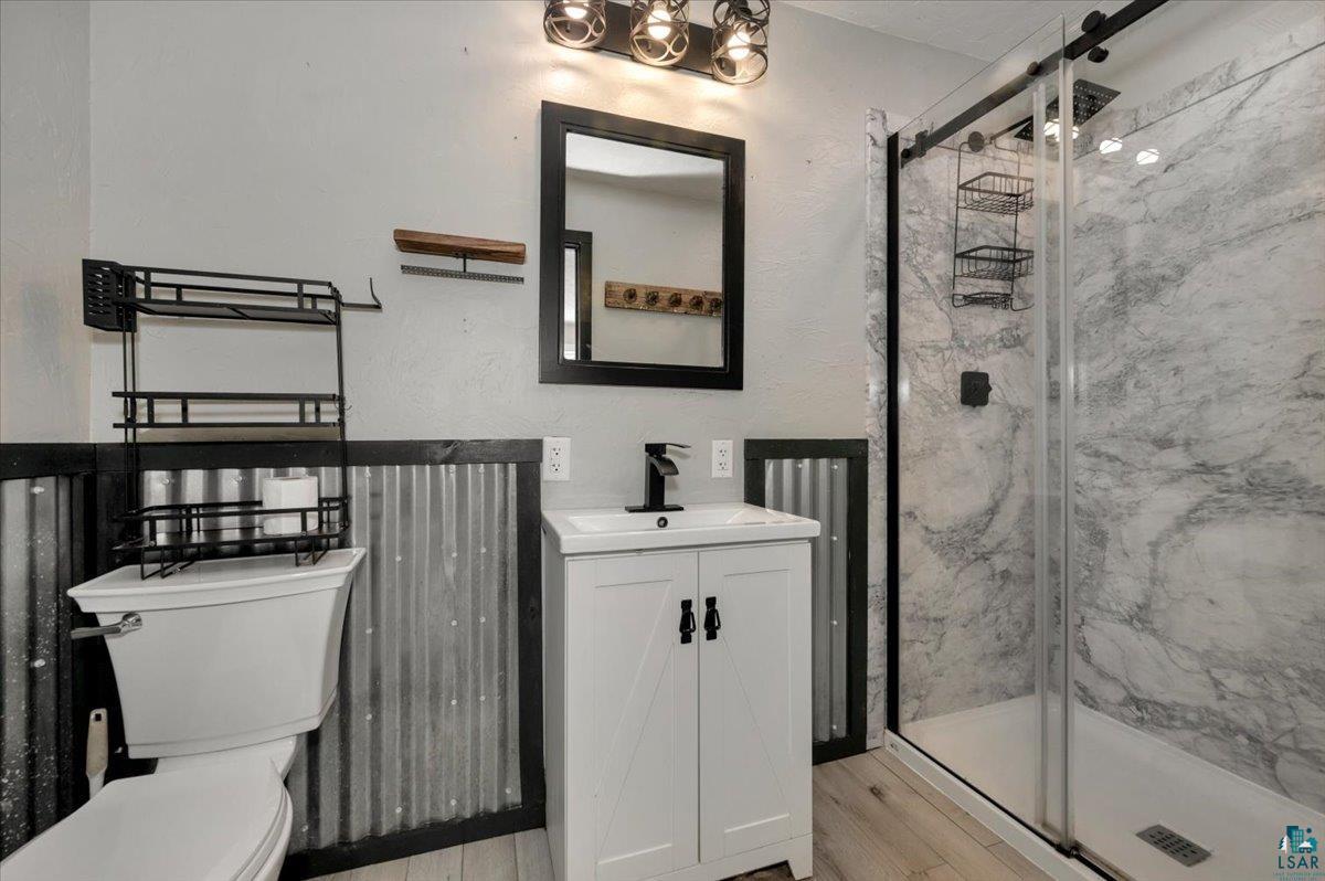 1146 Two Harbors Road Two Harbors, MN 55616 - Photo 13 of 39 Full bathroom featuring vanity, a marble finish shower, light wood-style floors, and a textured wall