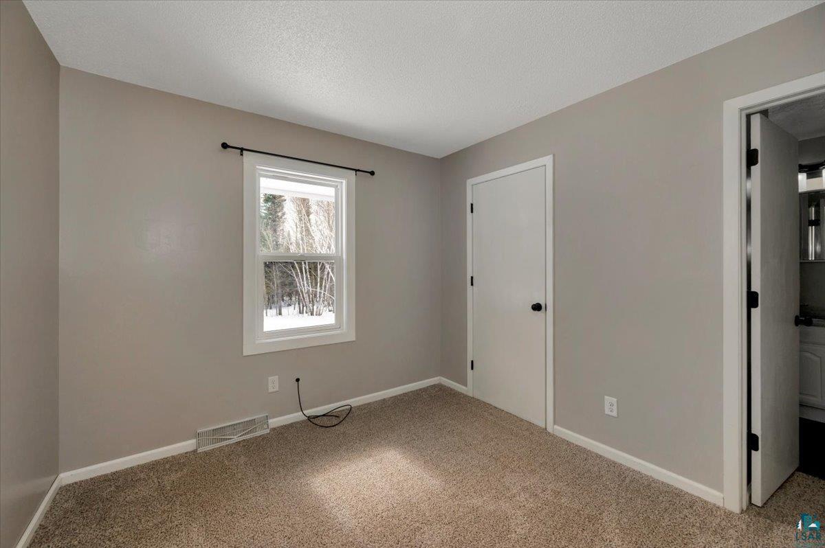 1146 Two Harbors Road Two Harbors, MN 55616 - Photo 14 of 39 Unfurnished bedroom with a textured ceiling and light carpet