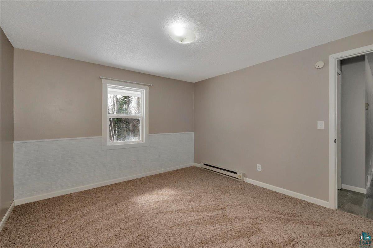 1146 Two Harbors Road Two Harbors, MN 55616 - Photo 18 of 39 Carpeted spare room featuring baseboard heating and a textured ceiling