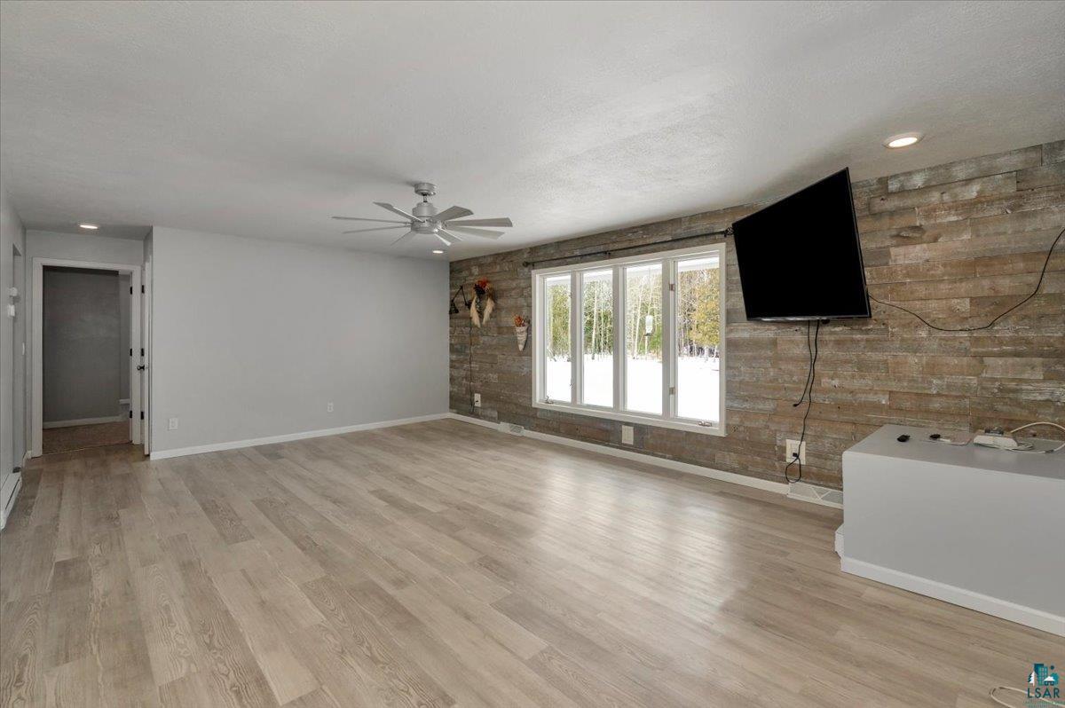 1146 Two Harbors Road Two Harbors, MN 55616 - Photo 4 of 39 Unfurnished living room featuring light wood-style floors, ceiling fan, brick wall, and recessed lighting