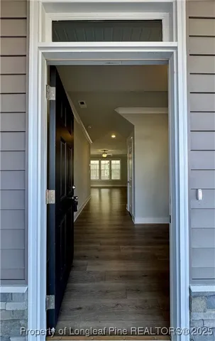 an empty room with wooden floor fireplace and windows