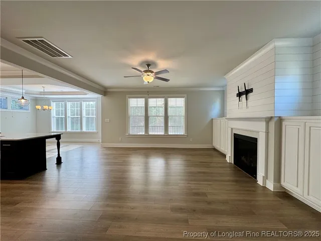 a view of empty room with wooden floor and fireplace