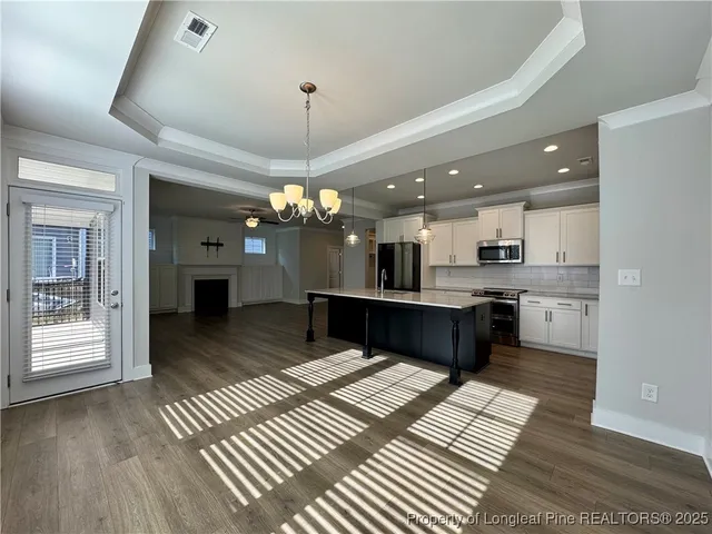 a kitchen with stainless steel appliances granite countertop a stove a sink a refrigerator and a wooden cabinets