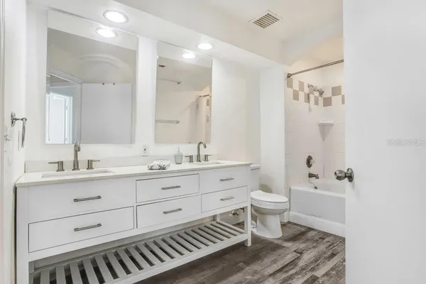 a bathroom with a double vanity sink toilet and a mirror