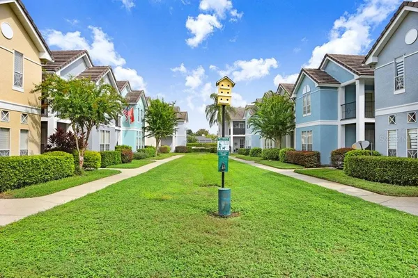 a view of a house with a yard and a tree