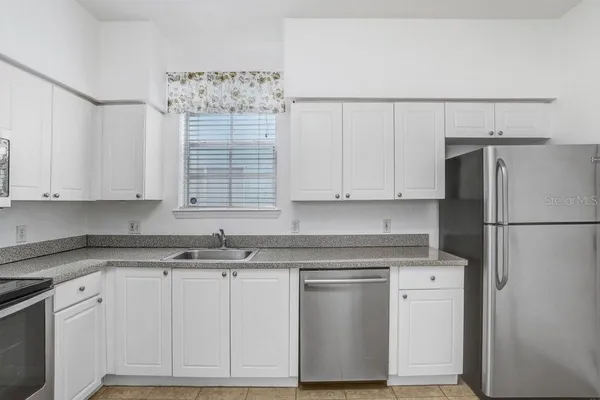 a kitchen with appliances a sink and cabinets