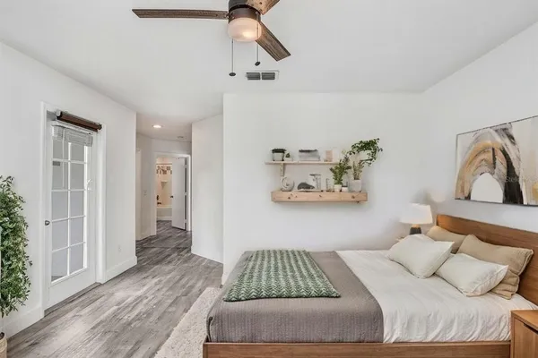 a bedroom with a bed and wooden floor