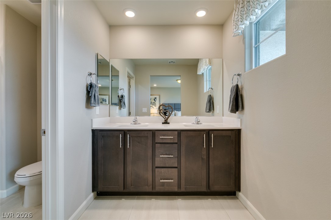 653 Pickled Pepper Place Henderson, NV 89011 - Photo 28 of 35 Dual vanities with ample counter space offer practical elegance in this primary bathroom.