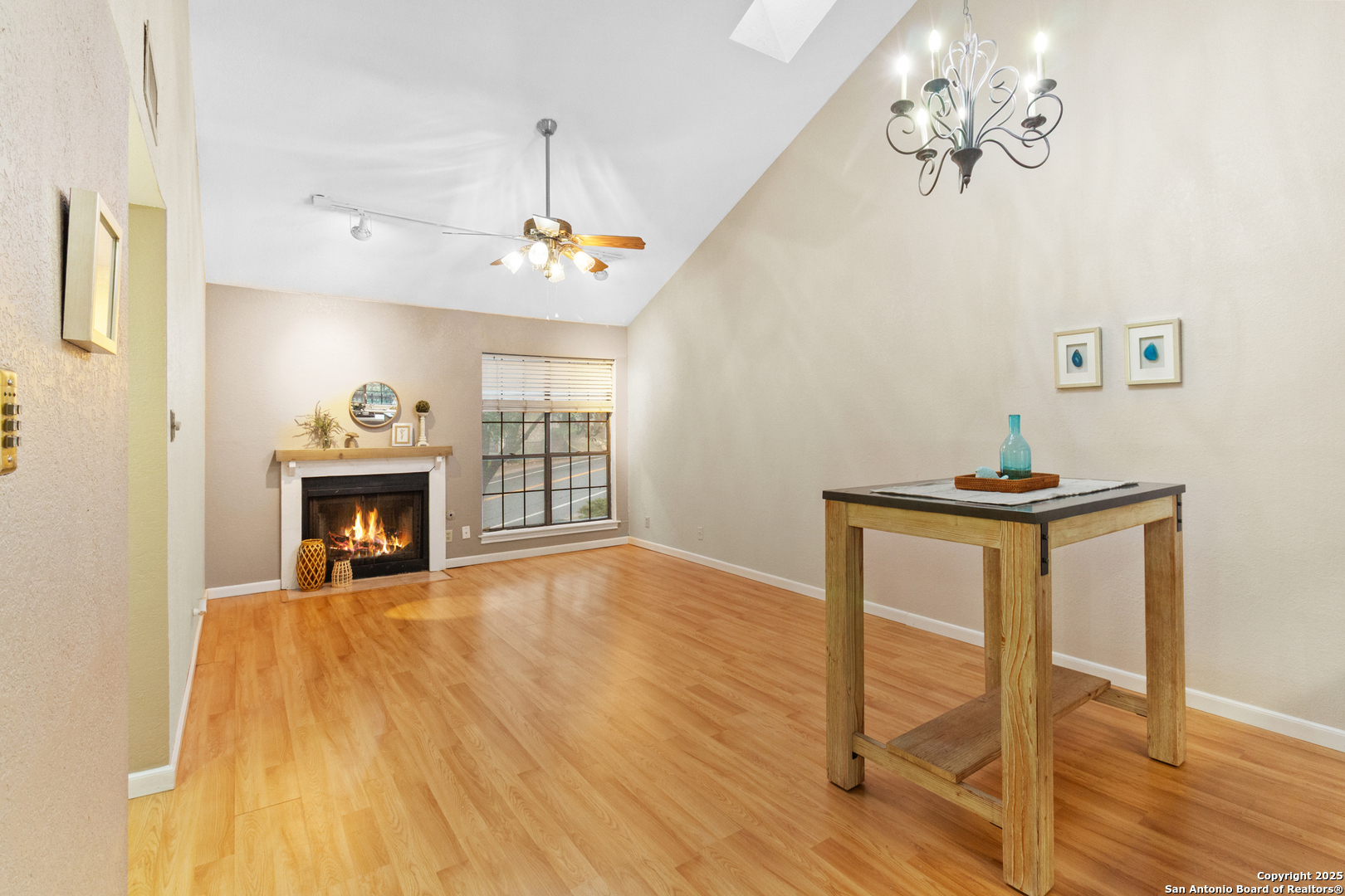 a view of a livingroom with a fireplace a chandelier and wooden floor
