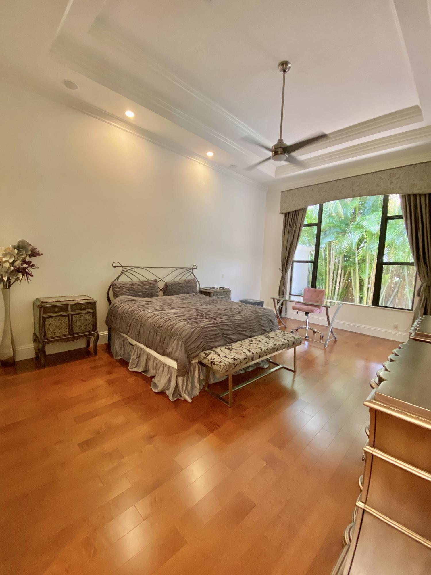 17754 Lake Azure Way Boca Raton, FL 33496 - Photo 22 of 30 a spacious bedroom with a bed and a chandelier