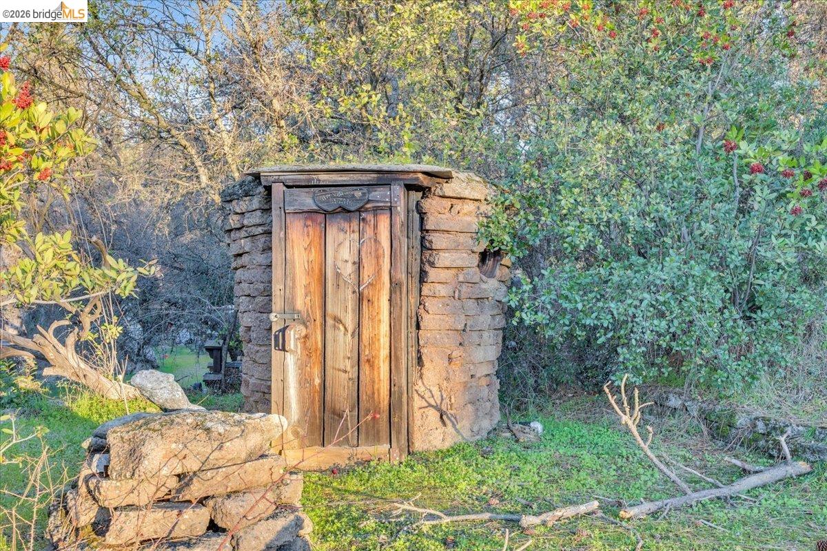 22389 Parrotts Ferry Road Columbia, CA 95310 - Photo 28 of 60 a stone house with trees in front of it