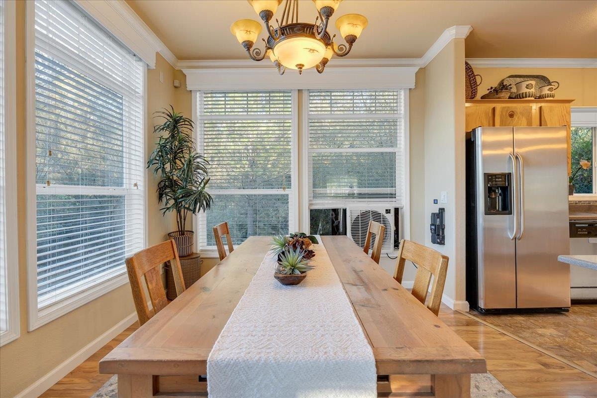 22389 Parrotts Ferry Road Columbia, CA 95310 - Photo 39 of 60 Dining area featuring ornamental molding, light wood-style flooring, and a chandelier
