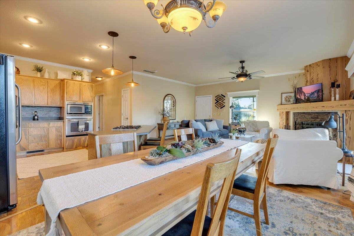 22389 Parrotts Ferry Road Columbia, CA 95310 - Photo 41 of 60 Dining area featuring a brick fireplace, ornamental molding, and a ceiling fan