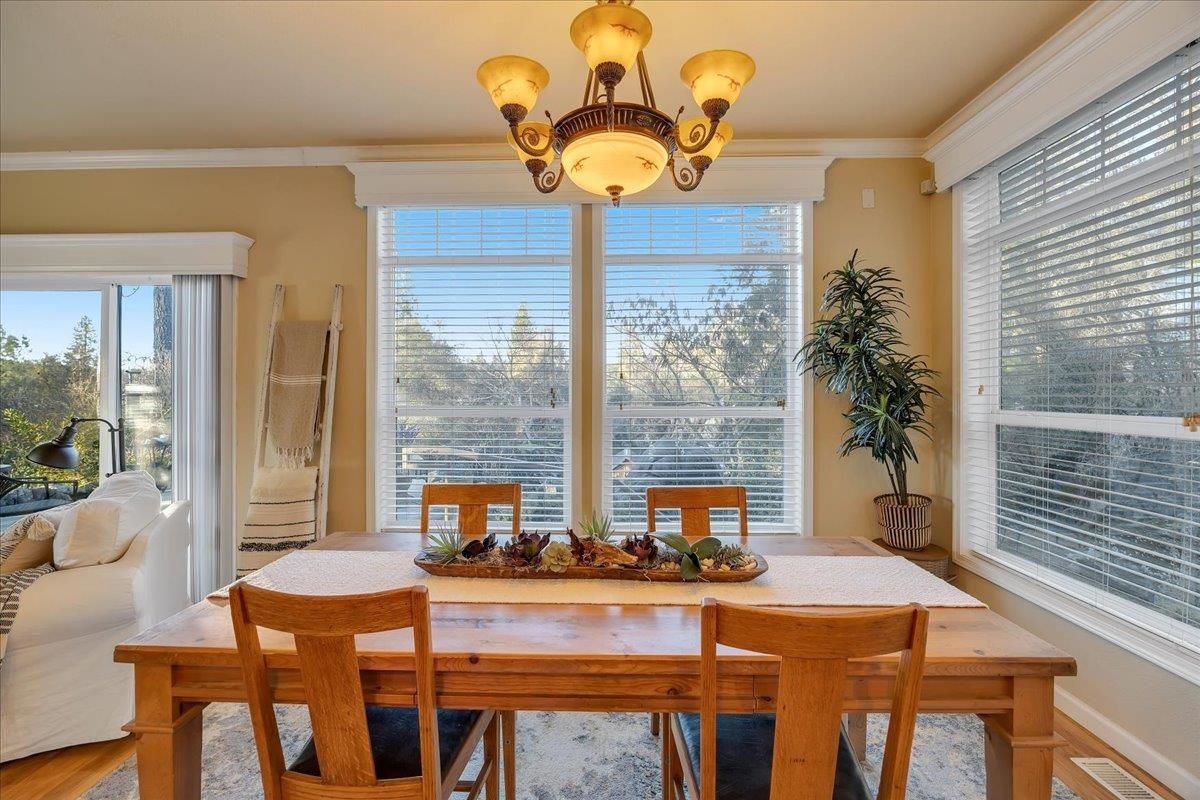 22389 Parrotts Ferry Road Columbia, CA 95310 - Photo 48 of 60 Dining area with a chandelier, crown molding, and wood finished floors