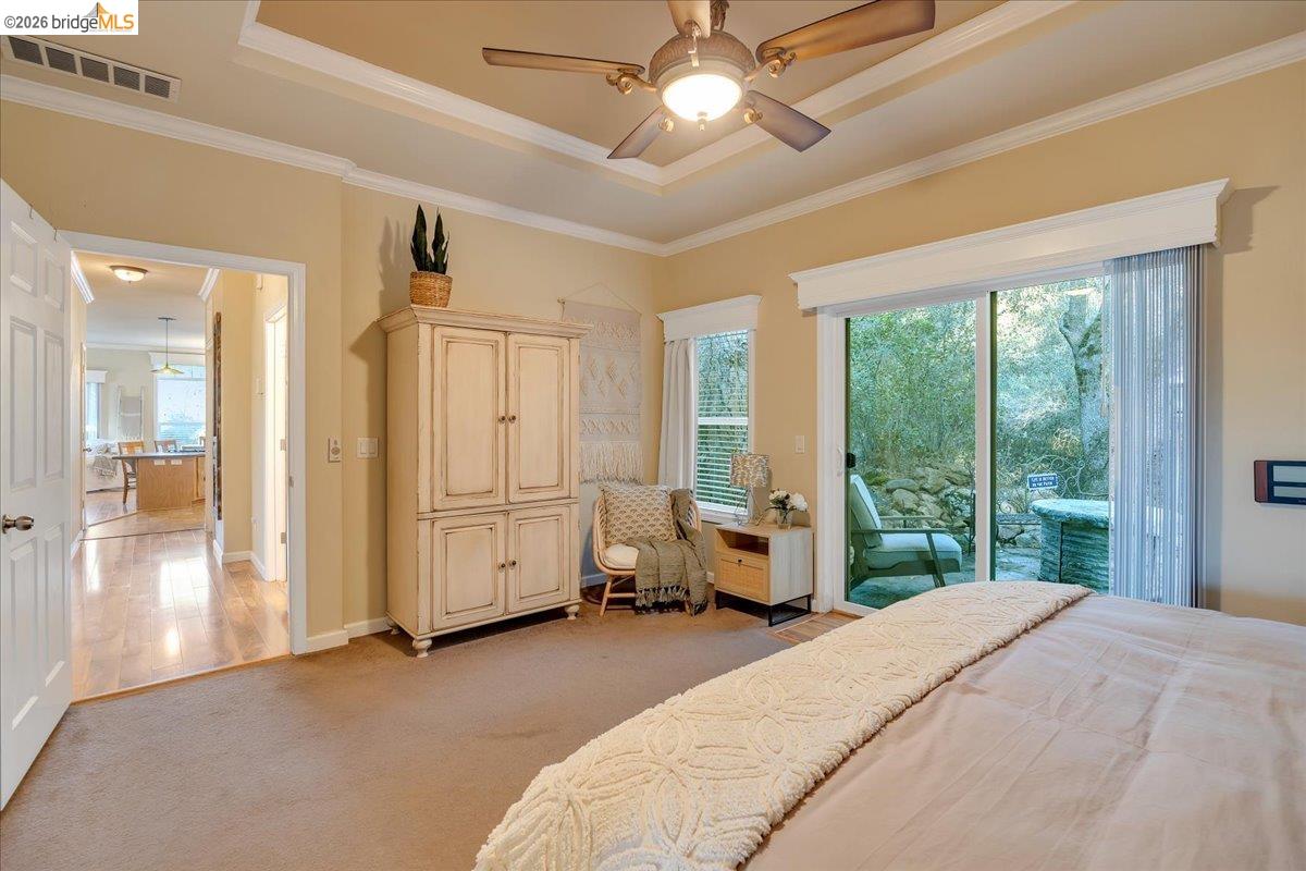 22389 Parrotts Ferry Road Columbia, CA 95310 - Photo 56 of 60 a spacious bedroom with a large bed and a chandelier fan