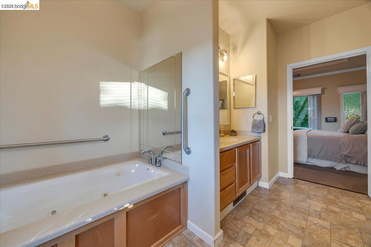 22389 Parrotts Ferry Road Columbia, CA 95310 - Photo 58 of 60 a spacious bathroom with a double vanity sink a mirror and a bathtub