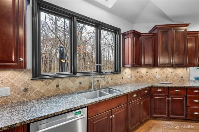 a kitchen with stainless steel appliances granite countertop a refrigerator and wooden cabinets