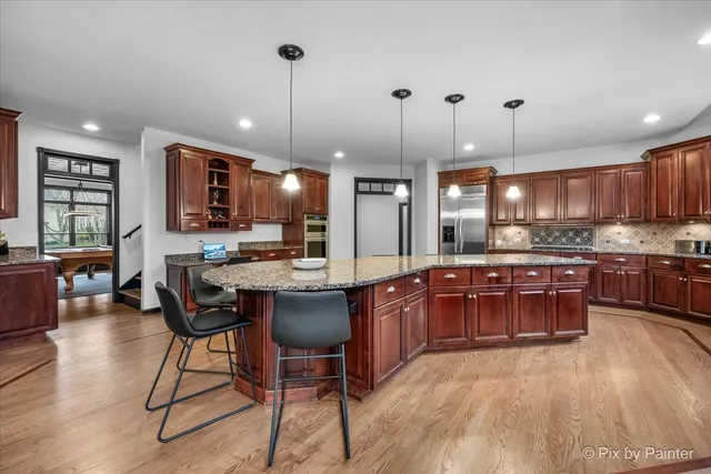 a view of a dining room and livingroom with furniture a rug a potted plant and a painting