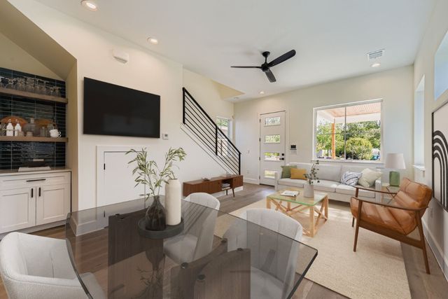 a living room with furniture a flat screen tv and a window