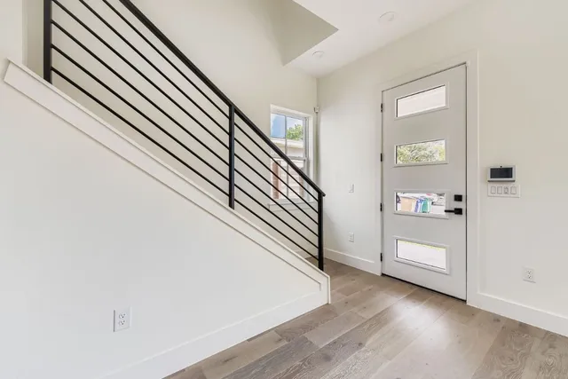 an entryway in a hall with a window and wooden floor