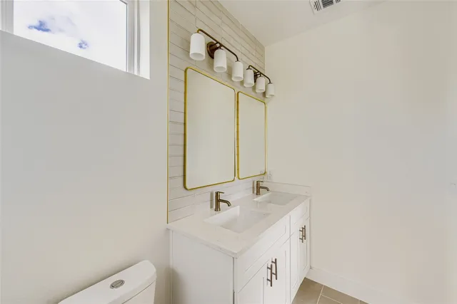 a bathroom with a sink a toilet and a mirror