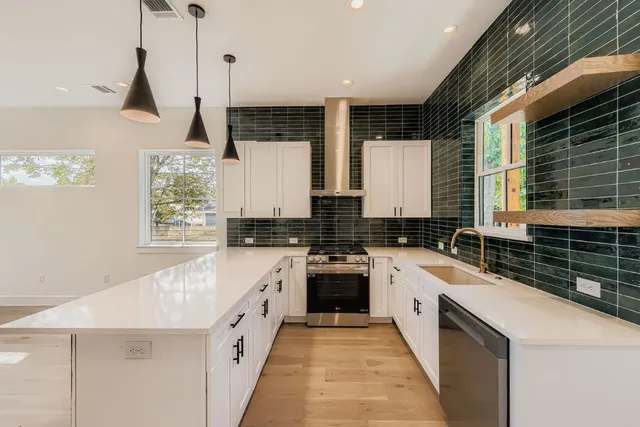 a kitchen with a white stove top oven sink and cabinets