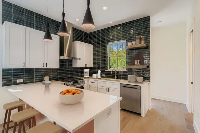 a kitchen with a sink a stove and chairs