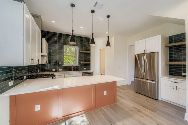 a kitchen with stainless steel appliances granite countertop a refrigerator a sink and a stove