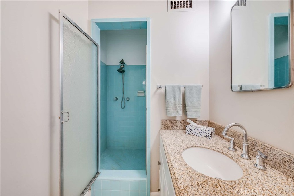 3665 Landfair Road Pasadena, CA 91107 - Photo 16 of 32 a bathroom with a granite countertop sink a mirror and shower