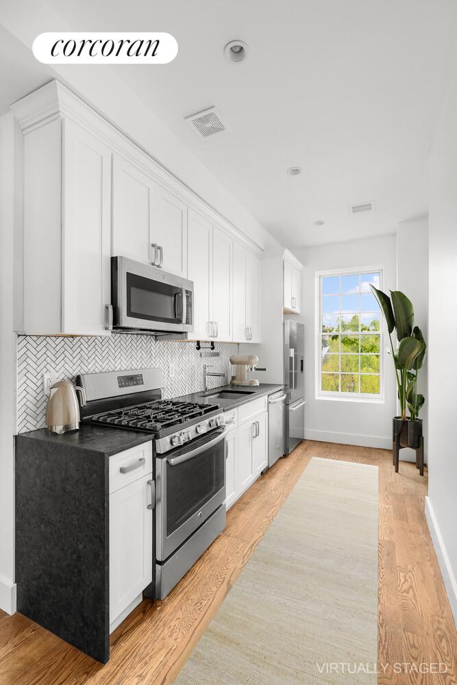 935 Lafayette Avenue, Unit 2 Brooklyn, NY 11221 - Photo 2 of 8 a kitchen with stainless steel appliances granite countertop a stove a sink and a microwave