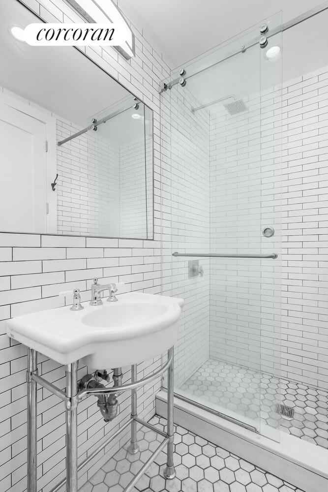 935 Lafayette Avenue, Unit 2 Brooklyn, NY 11221 - Photo 6 of 8 a bathroom with a sink mirror and shower