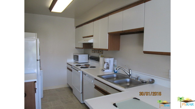 1150 East Amado Road, Unit 18D2 Palm Springs, CA 92262 - Photo 4 of 13 a kitchen with stainless steel appliances a sink stove and cabinets