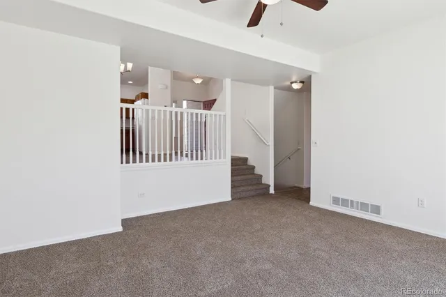 a view of an empty room with a ceiling fan