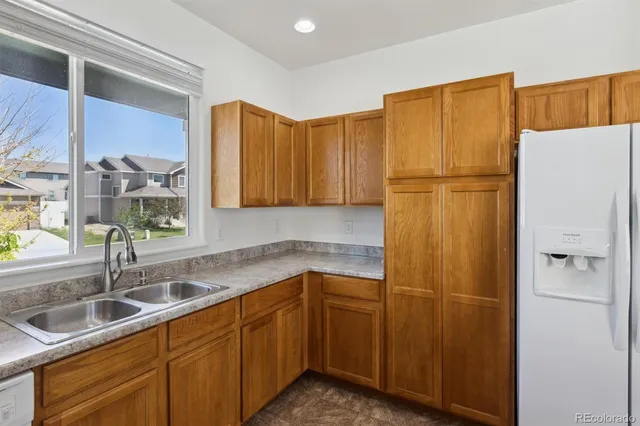 a kitchen with sink a refrigerator and cabinets